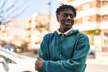 Sokakta eli kolu çapraz hareket eden Afrikalı Amerikalı bir adam.