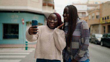 İki Afro-Amerikalı arkadaş gülümsüyor.
