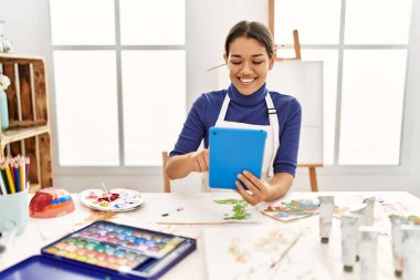 Resim stüdyosunda dokunmatik çizim yapan genç Latin kadın.