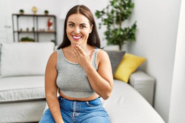 Genç ve güzel İspanyol kadın evdeki kanepede oturan sağırlarla iletişim kuruyor.