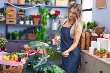 Young caucasian woman florist smiling confident working at florist