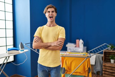 Delikanlı çamaşırları yıkıyor kızgın ve öfkeli çığlıklar atıyor öfkeyle bağırıyor. öfke ve agresif konsept. 