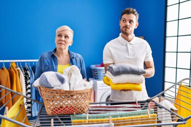 İspanyol anne ve oğlu çamaşır ipine asılmış gülümsüyor, yan tarafa bakıyor ve düşünüyor.. 
