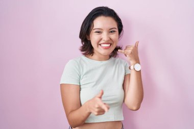 Pembe arka planda duran İspanyol genç kadın gülümsüyor telefonda konuşuyor ve seni işaret ediyor. Ara beni.. 