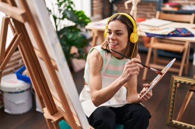 Sanat stüdyosunda müzik dinleyen genç, güzel İspanyol kadın sanatçı.