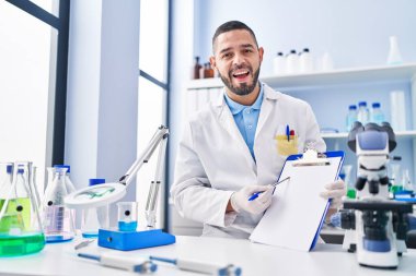 Laboratuvarda çalışan İspanyol bir adam elinde boş bir panoyla deliliği kutluyor ve başarıyı hayrete düşürüyor.. 