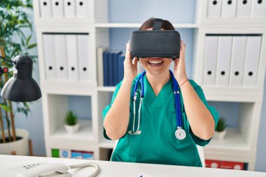 Genç, güzel İspanyol kadın doktor klinikte sanal gerçeklik gözlüğü kullanıyor.