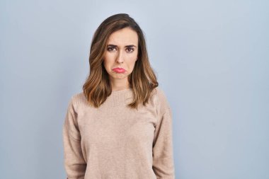 Young woman standing over isolated background depressed and worry for distress, crying angry and afraid. sad expression. 