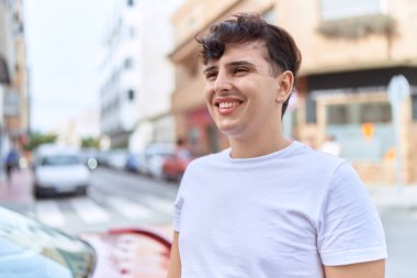 Non binary man smiling confident looking to the side at street
