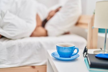 Genç İspanyol adam yatakta uzanıp yatak odasında uyuyor.