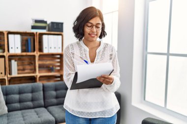 Psikoloji merkezindeki panoya psikoloji dersi alan genç Latin bir kadın.