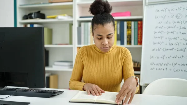 若いアフリカ系アメリカ人の女性が図書館で本を読んでいる — ストック写真