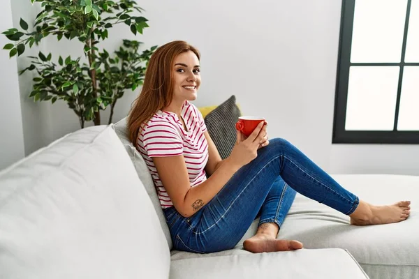 Young Woman Drinking Coffee Sitting Sofa Home — Zdjęcie stockowe