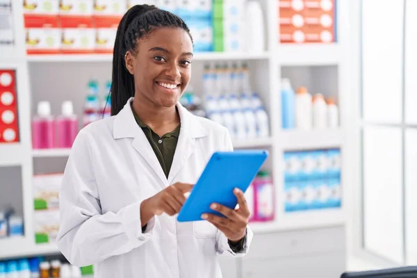 stock image African american woman pharmacist using touchpad working at pharmacy