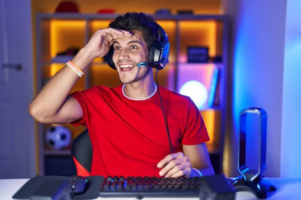 若いヒスパニック系の男は頭の上に手で遠く見て非常に幸せと笑みを浮かべてビデオゲームをプレイ 検索の概念 — ストック写真