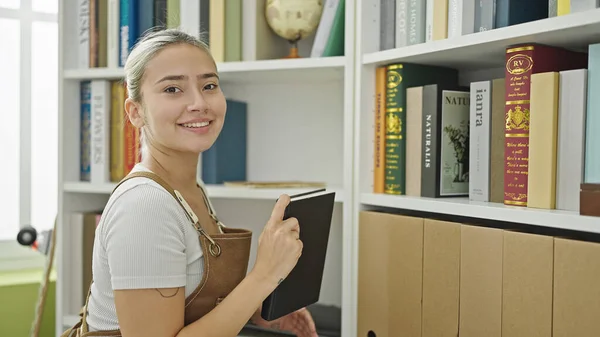 Jovem Bela Mulher Hispânica Estudante Sorrindo Confiante Segurando Livro Estantes — Fotografia de Stock
