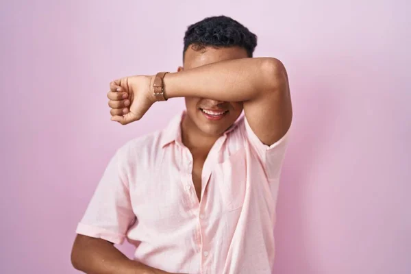 Young Hispanic Man Standing Pink Background Covering Eyes Arm Smiling — Zdjęcie stockowe
