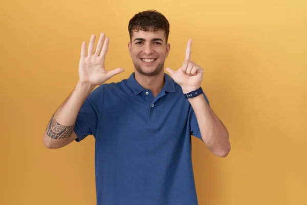 Mladý Hispánec Stojící Nad Žlutým Pozadím Ukazující Ukazující Prsty Číslo — Stock fotografie