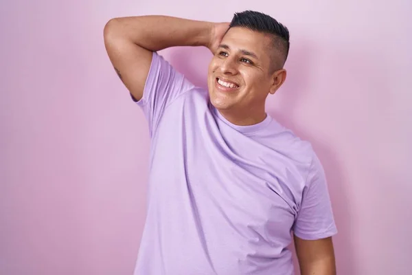 Молодой Латиноамериканец Стоящий Розовом Фоне Улыбающийся Уверенно Касающийся Волос Жестом — стоковое фото