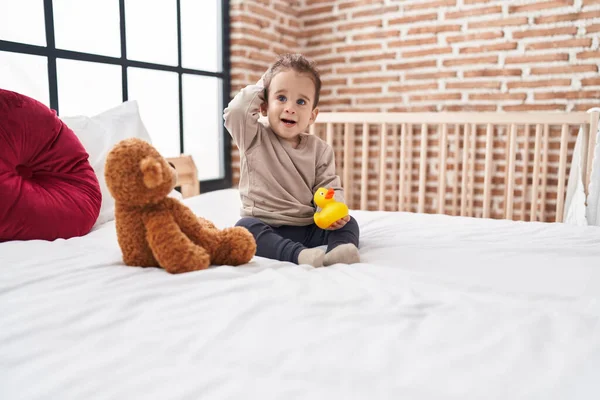 Adorável Hispânico Menino Segurando Pato Brinquedo Sentado Cama Quarto — Fotografia de Stock