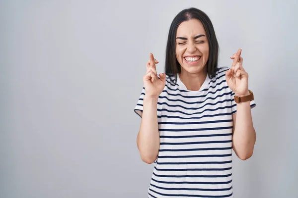 Jonge Brunette Vrouw Draagt Gestreept Shirt Gebaren Vinger Gekruist Glimlachen — Stockfoto