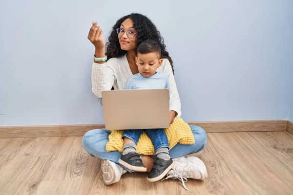 若いですヒスパニック系の母親と子供使用してコンピュータラップトップ座っています床にイタリアのジェスチャーを行います手と指で自信を持って式 — ストック写真