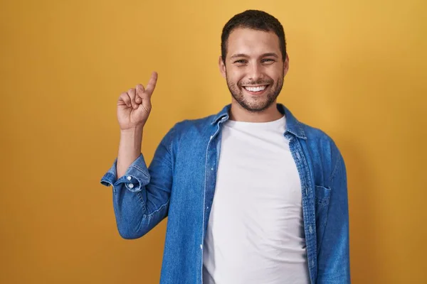 Hispanischer Mann Der Vor Gelbem Hintergrund Steht Und Mit Finger — Stockfoto