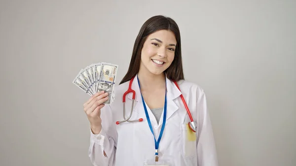 年轻美丽的惊慌失措的女医生微笑着 自信地拿着美元支撑着孤独的白色背景 — 图库照片