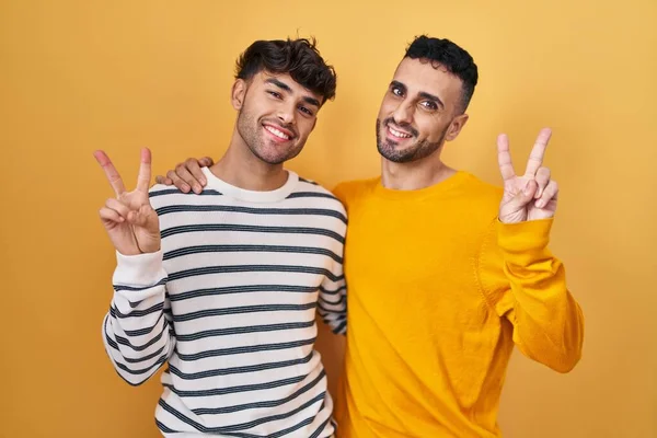 Jovem Casal Gay Hispânico Sobre Fundo Amarelo Sorrindo Olhando Para — Fotografia de Stock