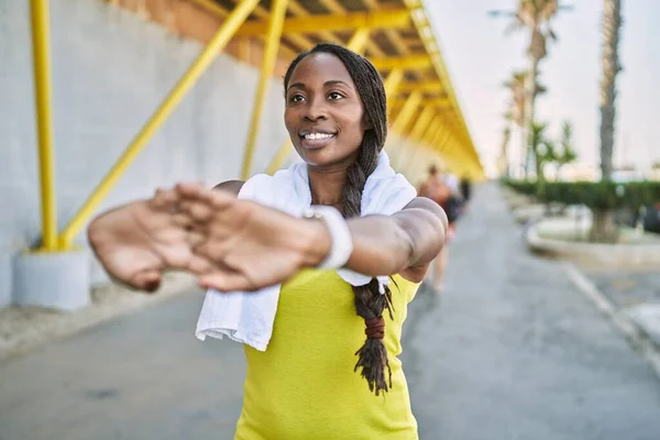ストリートでスポーツウェアストレッチ腕を身に着けているアフリカ系アメリカ人女性 — ストック写真