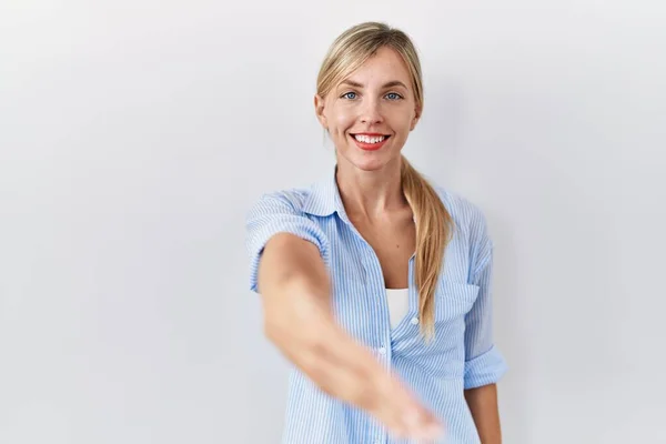 Mooie Blonde Vrouw Staat Witte Achtergrond Glimlachend Vriendelijk Aanbieden Van — Stockfoto