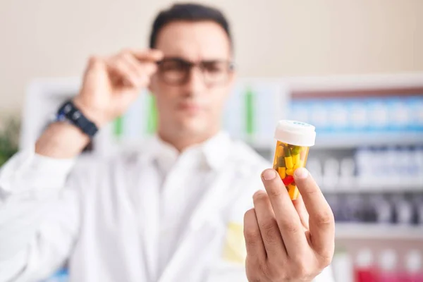 Young Hispanic Man Pharmacist Looking Pills Bottle Pharmacy — Stock Photo, Image