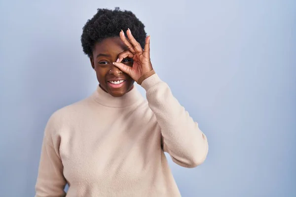 Afro Amerikalı Bir Kadın Mavi Arka Planda Duruyor Hareketleriyle Gülümsüyor — Stok fotoğraf