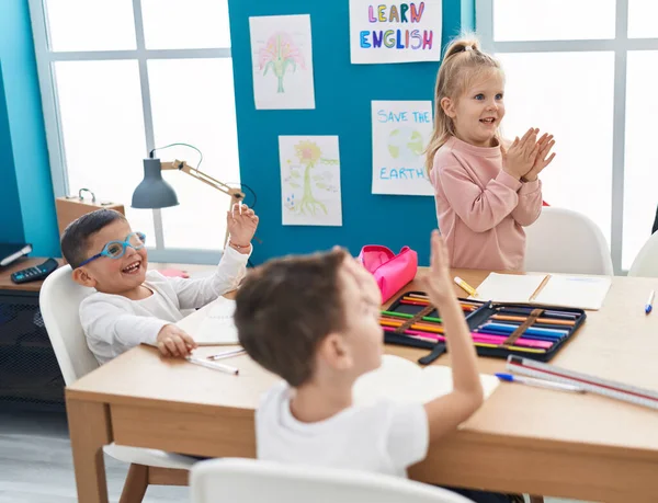 一群孩子坐在桌子上 在教室里拍手 — 图库照片