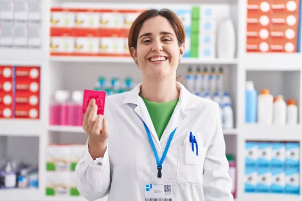 Brunette Woman Working Pharmacy Drugstore Holding Condom Looking Positive Happy — Stock Photo, Image