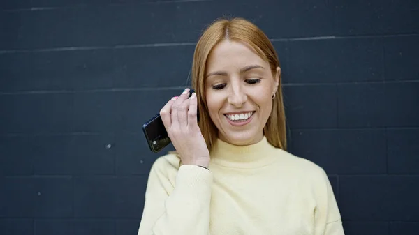 Молодая Блондинка Улыбается Уверенно Слушая Аудио Сообщение Смартфона Изолированном Черном — стоковое фото