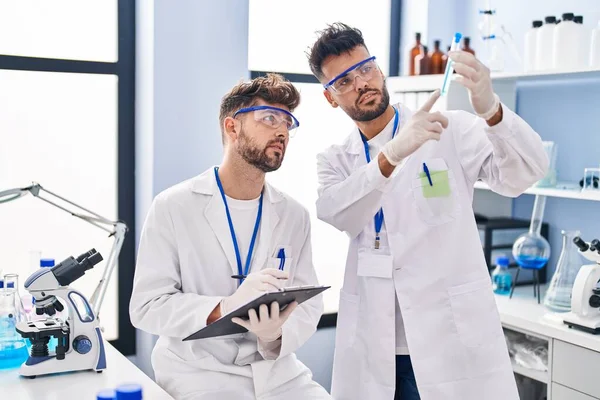 stock image Young couple wearing scientist uniform working at laboratory