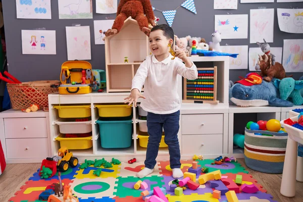愛らしいヒスパニック男の子遊びますともに恐竜のおもちゃスタンディングで幼稚園 — ストック写真