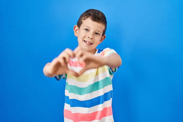 Mavi Arka Planda Dikilen Beyaz Bir Çocuk Sevgiyle Gülümsüyor Elleriyle — Stok fotoğraf