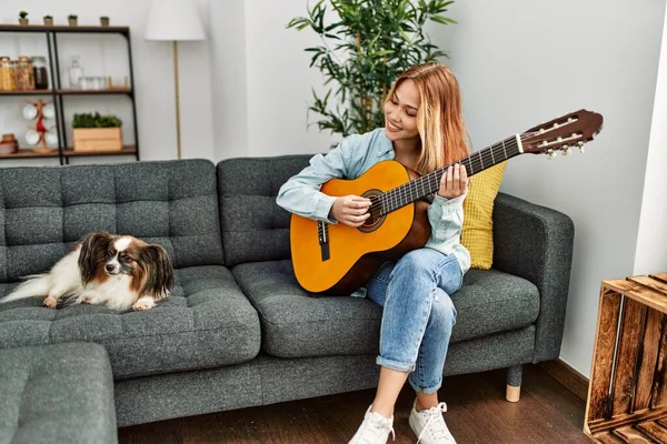 Jovem Caucasiana Tocando Guitarra Clássica Sentada Sofá Com Cão Casa — Fotografia de Stock