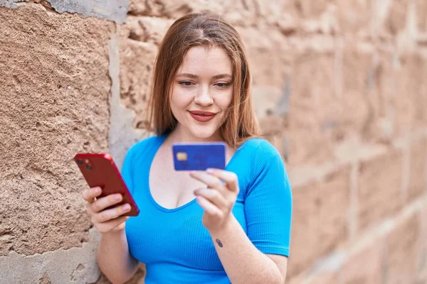 Jonge Roodharige Vrouw Met Behulp Van Smartphone Creditcard Geïsoleerde Baksteen — Stockfoto