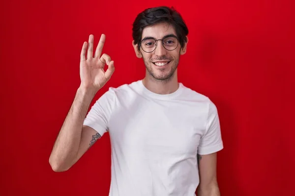Homem Hispânico Jovem Sobre Fundo Vermelho Sorrindo Positivo Fazendo Sinal — Fotografia de Stock