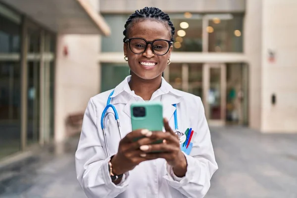 Mujer Afroamericana Doctora Sonriendo Confiada Usando Smartphone Hospital —  Fotos de Stock