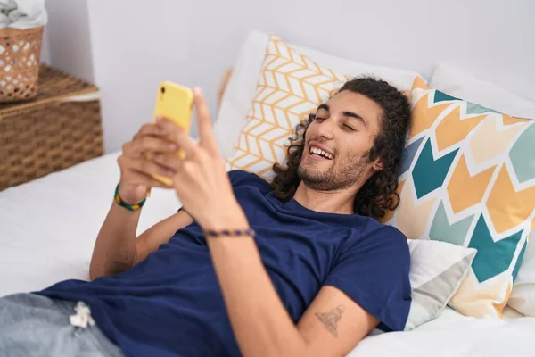 Jovem Hispânico Usando Smartphone Deitado Cama Quarto — Fotografia de Stock
