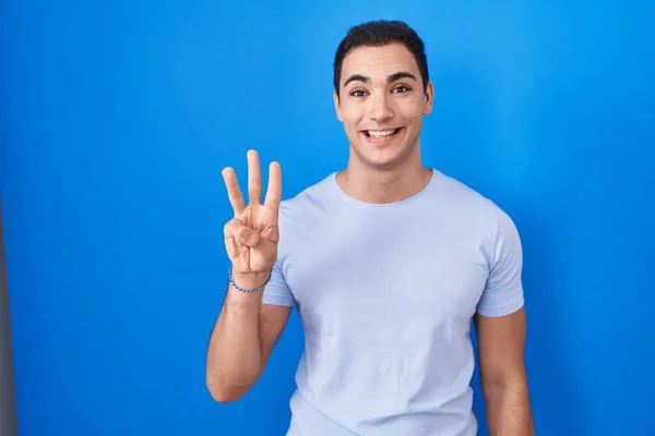 Young Hispanic Man Standing Blue Background Showing Pointing Fingers Number – stockfoto