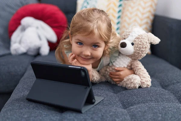 Adorável Menina Loira Assistindo Vídeo Touchpad Deitado Sofá Casa — Fotografia de Stock