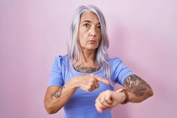 Μεσήλικας Γυναίκα Τατουάζ Στέκεται Πάνω Από Ροζ Φόντο Βιασύνη Δείχνει — Φωτογραφία Αρχείου