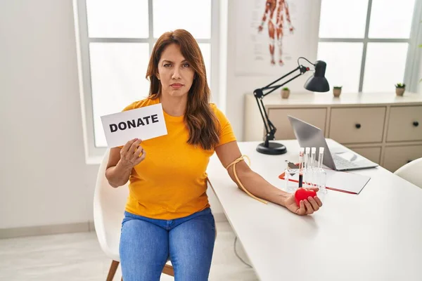 Hispanic woman supporting blood donation skeptic and nervous, frowning upset because of problem. negative person.