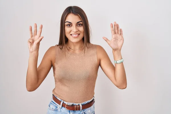 Beyaz Arka Planda Duran Genç Spanyol Kadın Dokuz Numaralı Parmaklarını — Stok fotoğraf
