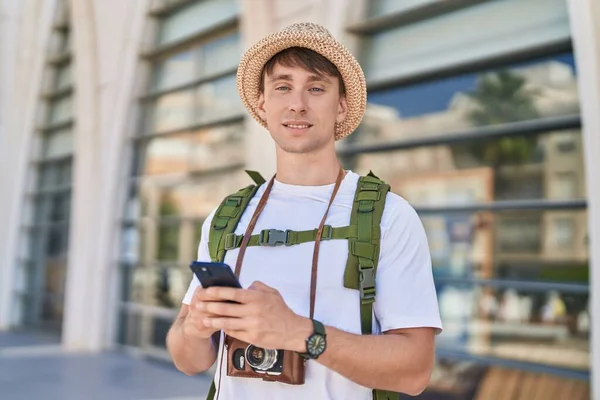 若いです白人男性観光客笑顔自信を持って使用してスマートフォンでストリート — ストック写真